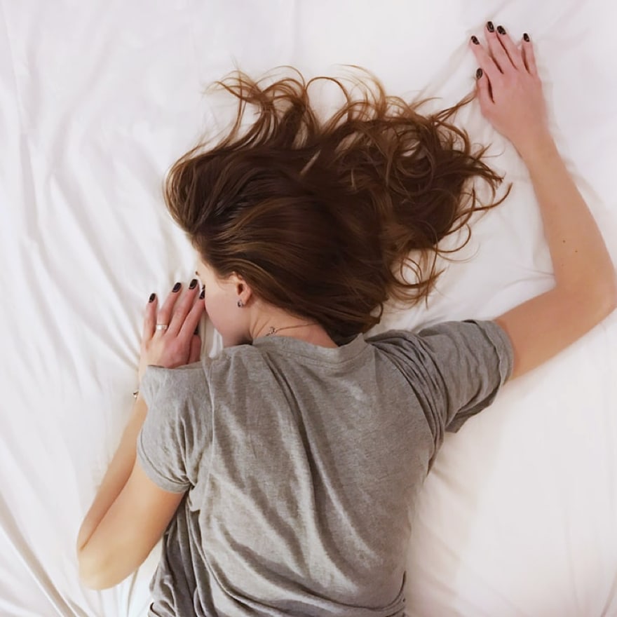 Une femme est allongée dans un lit.