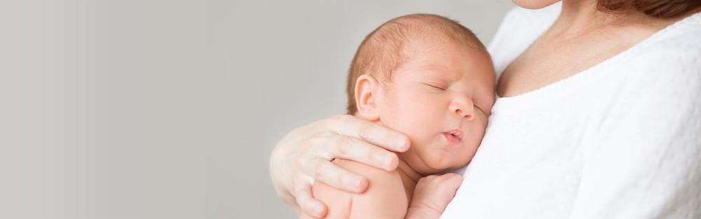 Mutter stillt ihr neugeborenes Baby mit der Brust