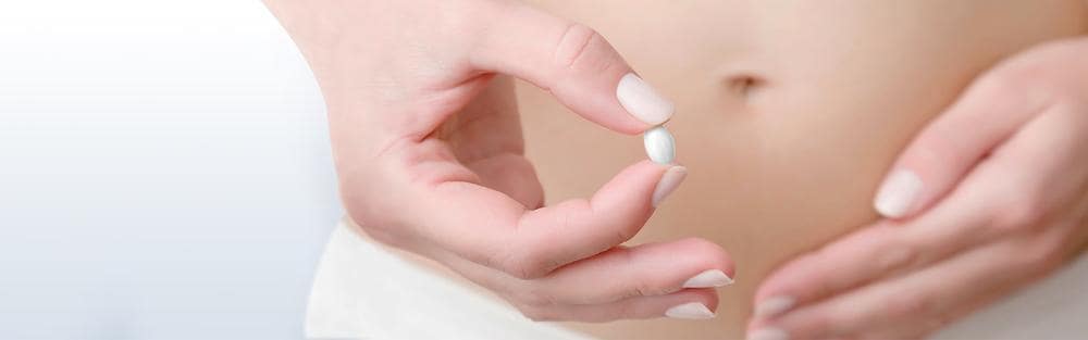 Frau mit einer Pille in der Hand